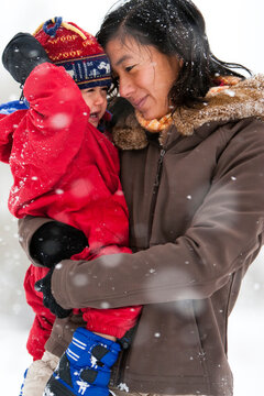 A mother plays with her toddler son in his first big snowstorm in Fort Collins, Colorado.