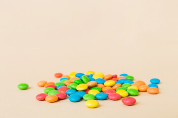 Pile of delicious colorful sweet candies on colored background top view. Confectionery decor