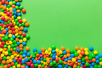 Mixed collection of colorful candy, on colored background. Flat lay, top view. frame of colorful chocolate coated candy