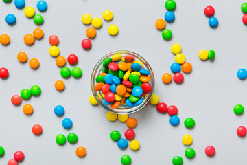 Multicolored candies in a bowl on a colored background. birthday and holiday concept. Top view with copy space