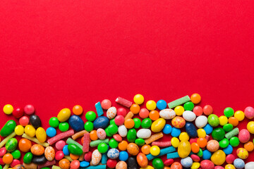 Mixed collection of colorful candy, on colored background. Flat lay, top view. frame of colorful chocolate coated candy