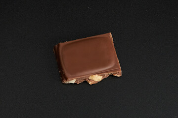 Piece of black chocolate on black background isolated path