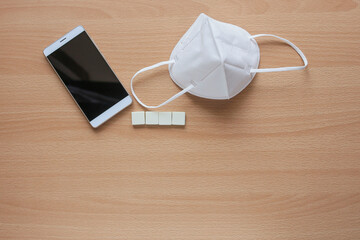 Fototapeta na wymiar A group of white cubes with face mask and a smartphone 