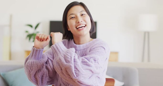 Portrait of happy asian woman having video call in living room