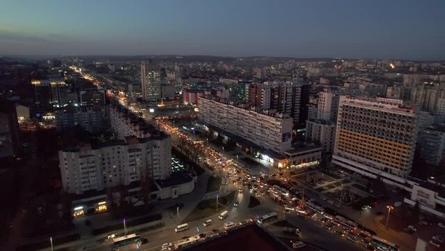 Aerial drone view of Chisinau at sunset, Moldova. View of city centre with multiple buildings, roads with traffic, illumination
