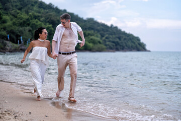 Love couple on holiday happy playing running along the beach and sweet kiss on love emotion