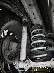 Dirty Automotive shock absorbers and springs installed in cars. - obrazy, fototapety, plakaty