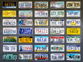 Collection of old license plates displayed on a wooden wall. - obrazy, fototapety, plakaty