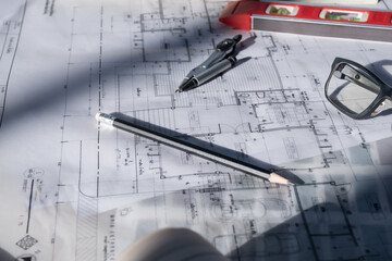 Architect concept, Architects working with blueprints in the office Business accessories (laptop, smartphone, pens, magnifier), accessories for drawing (plans, rulers) and learning on the table