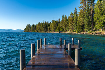Naklejka premium Sugar Pine Beach Park in South Lake Tahoe, California with Piers, Blue Lake, Sand, Water, Greenery and room for text.