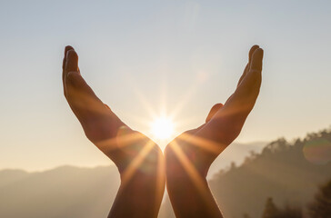 Fototapeta na wymiar Silhouette hands holding the sun at dawn