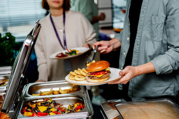 Man picking up food to a plate at a buffet in a hotel.