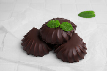 Delicious chocolate covered zephyrs with mint on white table