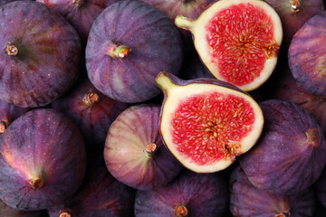 Cut and whole fresh ripe figs as background, top view