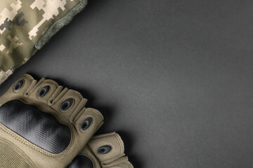 Tactical gloves and uniform on black background, flat lay with space for text. Military training...