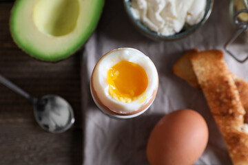 Soft boiled egg served for breakfast on wooden table, flat lay