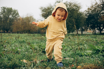 happy child on a walk on the street keeps the balance on the log