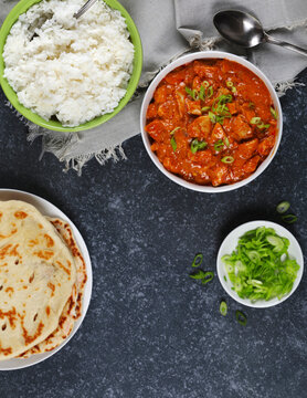 Butter chicken served with rice and flatbread