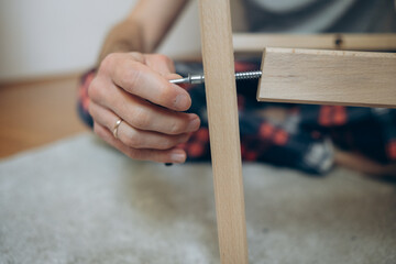 a man collects wooden furniture with his own hands