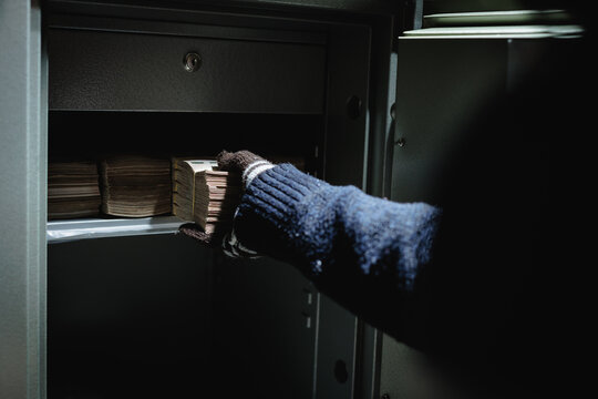 Steal wearing a glove thief and bring out money from safe box. Keep money and valuables in the vintage safe box steel. Stealing or keeping money and valuables safe.