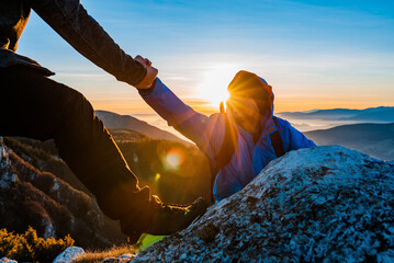 Hiking team people helping each other friend giving a helping hand while climbing up on the mountain rock adventure travel concept of friendship support trust teamwork success. - obrazy, fototapety, plakaty