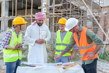 Diverse team of professionals using tablet computers on construction site. Real estate construction project. with civil engineers, architects, Arabic business investors and explorer with theodolite