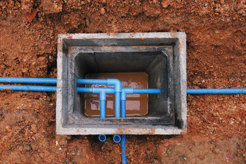 Blue PVC water pipe connect junction inside cement concrete ground box