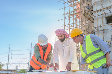 Diverse team of professionals using tablet computers on construction site. Real estate construction...