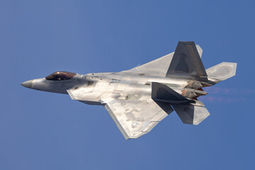 Fototapeta na wymiar Close side view of a F-22 Raptor in beautiful light , with afterburners on