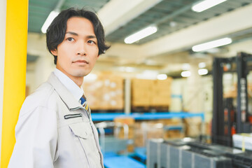 Fototapeta premium 作業服を着て倉庫で働く若いビジネスマン