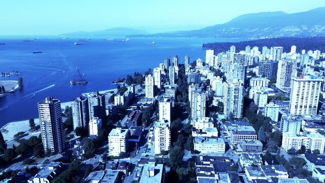 barge beached in Vancouvers sunset beach business as usual as speed boats pass by and tourists enjoy the view aerial panoramic flyover westside of downtown BC mountain overview reveal 4k beauty