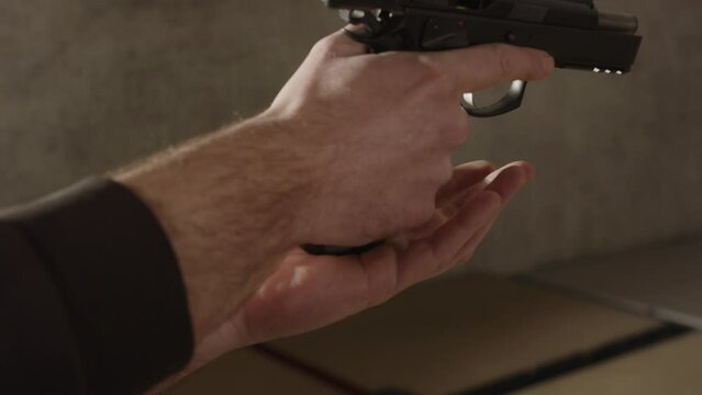 Loaded magazine being put into 9mm pistol and slide closing in slow motion