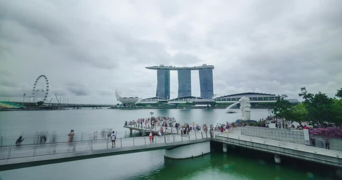 timelapse view of singapore marina bay area with highrise skyscraper buildings and merlion statue famous landmark of singapore with many tourist people