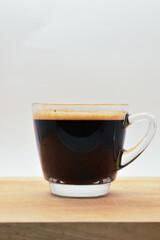 glass of hot black coffee put on wood background