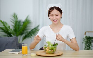Cheerful young Asian woman happy eating healthy food