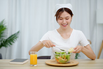 Cheerful young Asian woman happy eating healthy food