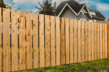 Nice wooden fence around house. Wooden fence with green lawn. Street photo