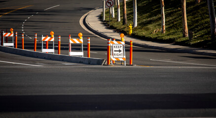Traffic sign and cones around construction of a cement street island - obrazy, fototapety, plakaty