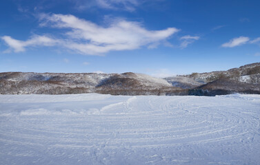 Snow fields with tire tracks and beautiful landscape