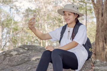 A 14-year-old Asian teenage girl taking a selfie on her phone.