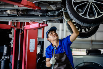 Auto mechanic repairman using a socket wrench working auto suspension repair in the garage, change...