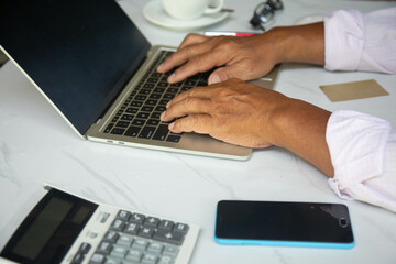 Businessman making his own taxes through a laptop on the desk.