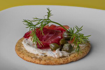 cured salmon on top of a cookie in fancy presentation 
