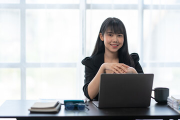 Business asian woman working on laptop computer managing her business in workplace, doing calculator planning document analyzing the financial report, business plan investment, finance analysis.