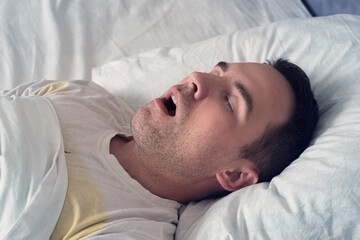 Portrait of a man sleeping with an open mouth. problem of snoring during sleep. A young cute guy...