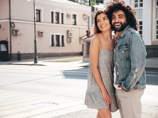 Smiling beautiful woman and her handsome boyfriend. Sexy cheerful family having tender moments in the street at sunset. Models hugging. Embracing each other. Love concept. In sunglasses