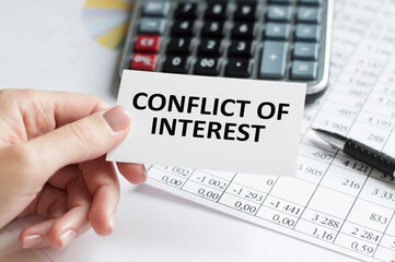 a man in the office holds a card with text CONFLICT OF INTEREST . business concept
