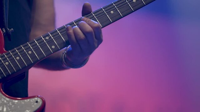 Man in rock band playing electric guitar on concert stage, Close up hand shot