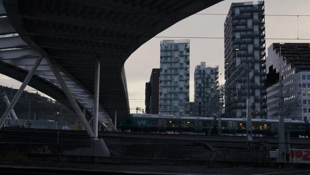 Trains moving into Oslo central station, late on a clear day in fall. Oslo Barcode is the backdrop