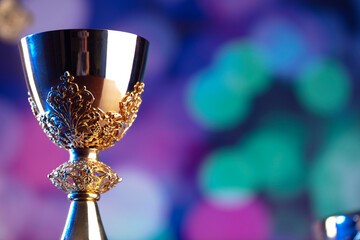 Religion theme. Religion symbols composition. The Cross, monstrance,  Holy Bible, rosary and golden chalice on blue bokeh background. 